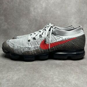 gray nike shoes with red swoosh